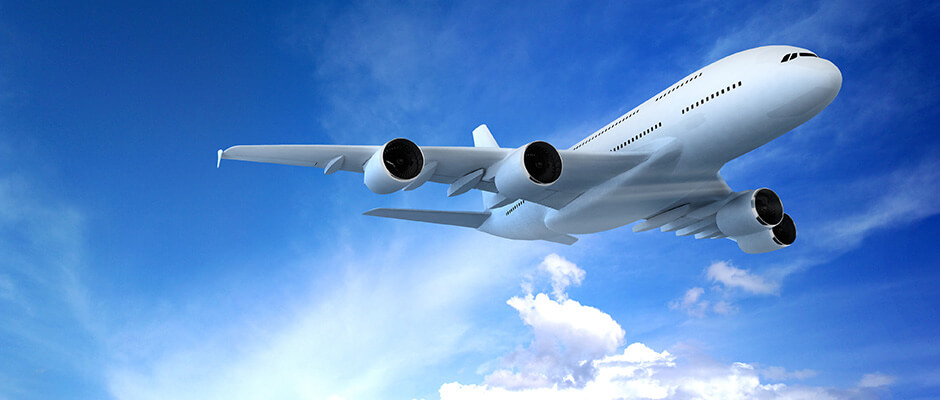 Airplane flying in partly cloudy sky